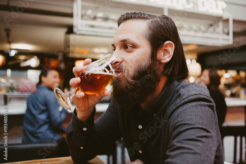 man drinking a beer in a restaurant