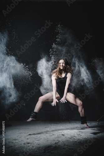 Girl dansing with flour on black background