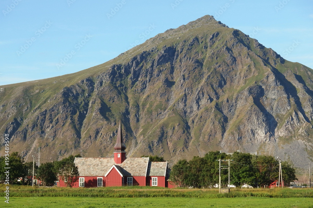 Norweskie wyspy Lofoty - czerwony drewniany kościół u podnóża góry - obrazy, fototapety, plakaty 