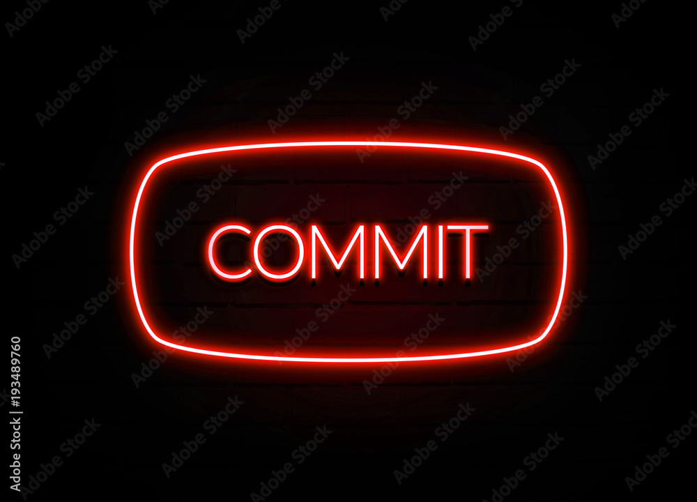 Commit neon sign on brick wall background.