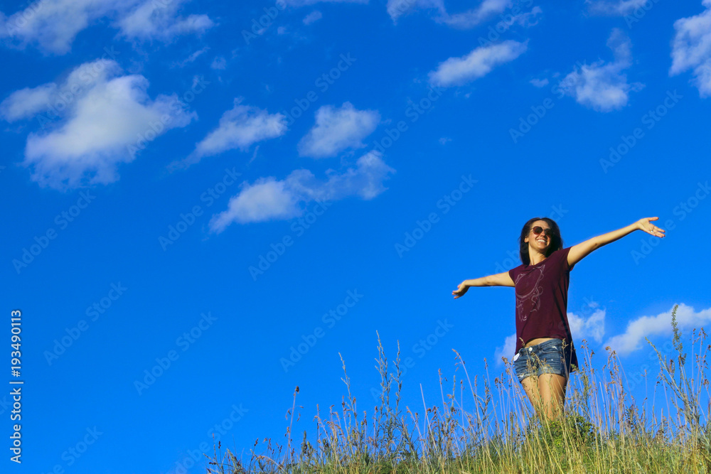 Young Woman Walking.Portrait Of A Carefree And Attractive Young Woman Outdoor Over Blue Sky Background. Woman On A Mountain Top. 