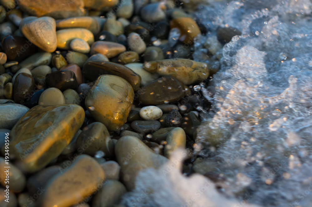 pebble stones on the sea beach, the rolling waves of the sea with foam pebble stones on the sea beach, the rolling waves of the sea with foam