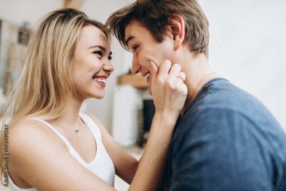 Happy couple spend time together in a large light bedroom. They are very happy and funny together Happy couple spend time together in a large light bedroom. They are very happy and funny together
