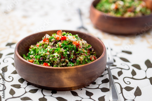 Healthy vegetarian salad bowl. This healthy dish mixes tabbouleh & greek style salads, using fresh parsley herb, olives, onions, feta and replacing the bulgur usually found in tabouleh with quinoa. photo