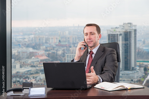 manager office / manager hard works in the office on the top floor building next to the window 