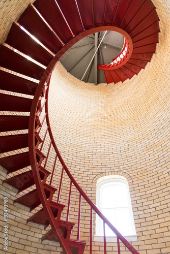 Red iron spiral staircase inside a lighthouse