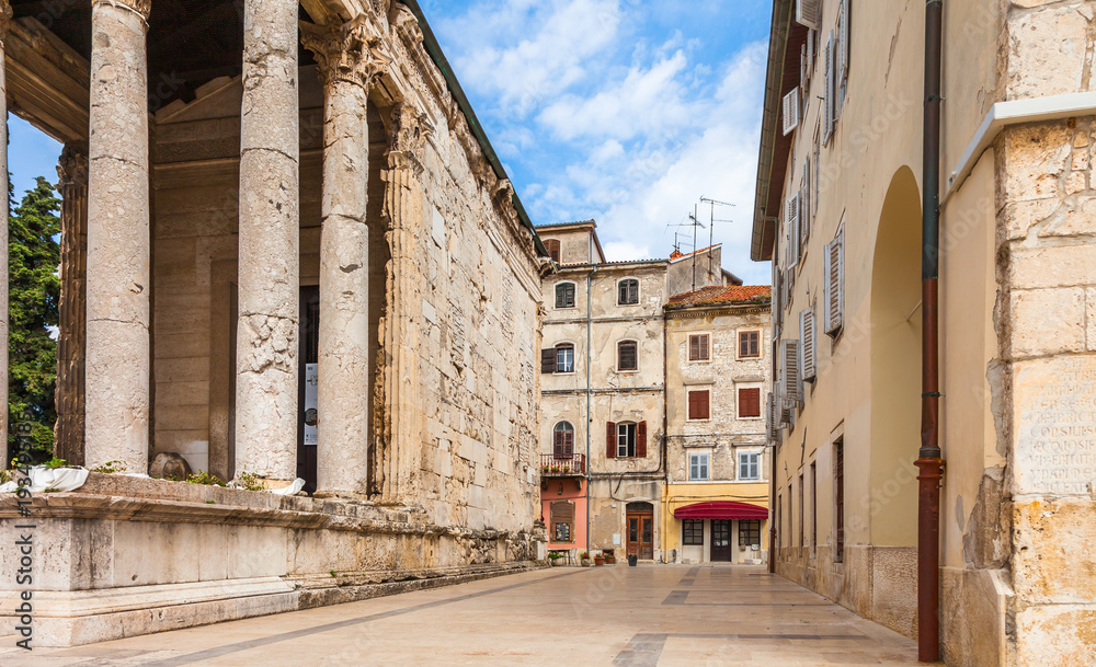 Old houses in background of the ancient Roaman temple of Augustus in old town Pula city, Croatia.