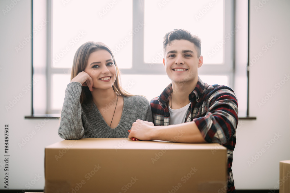 Young tired satisfied couple relaxing on floor with boxes. happy homeowners holding hands dreaming of future changes in new home after relocation. man and woman feeling pleasant fatigue on moving day Young tired satisfied couple relaxing on floor with boxes. happy homeowners holding hands dreaming of future changes in new home after relocation. man and woman feeling pleasant fatigue on moving day