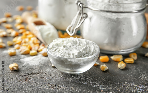 Bowl with corn starch and kernels on table