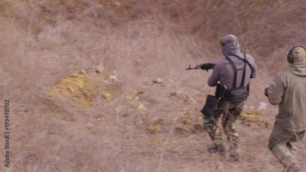 Male training with rifle or shotgun outdoors in field. Sport shooting competitions. Male training with rifle or shotgun outdoors in field. Sport shooting competitions.