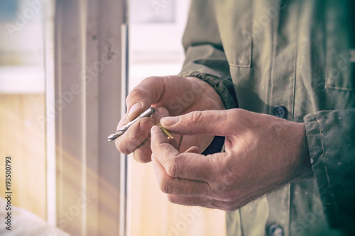 Carpenter holds drill bit and screw