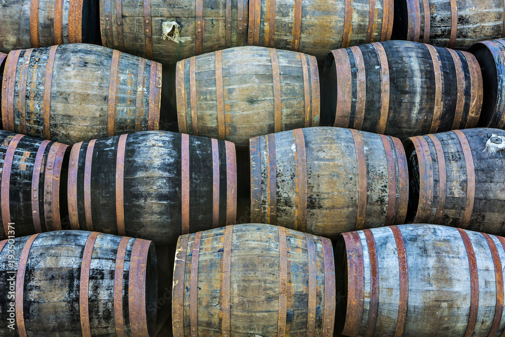 Stacked pile of old wooden barrels and casks at whisky distillery in Scotland Stacked pile of old wooden barrels and casks at whisky distillery in Scotland