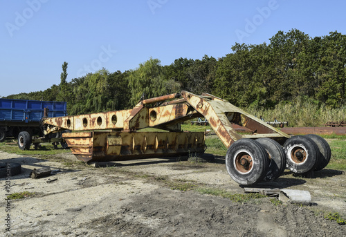 Grader on a trailer for heavy equipment. Trailer Hitch for tractors and combines. Trailers for agricultural machinery. photo