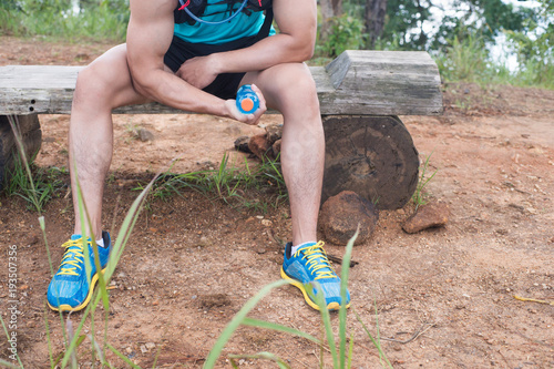 Bottle of orange juice in hands of trail runner visitor