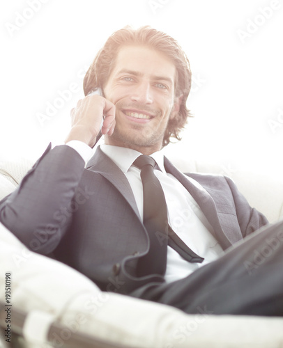 business man talking on a smartphone while sitting in a comforta photo