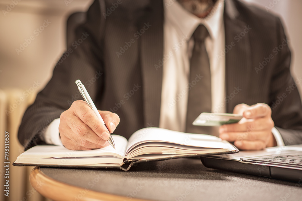 Senior business man writing down calculations Senior business man writing down calculations