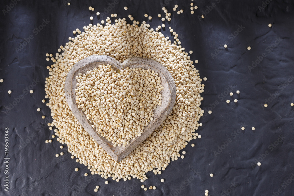 Quinoa grains with spoon and bowl on black background Quinoa grains with spoon and bowl on black background