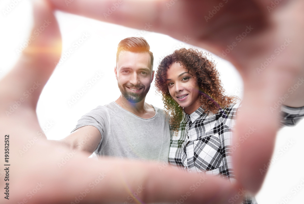 Fototapeta premium newlyweds look in the frame of the fingers.