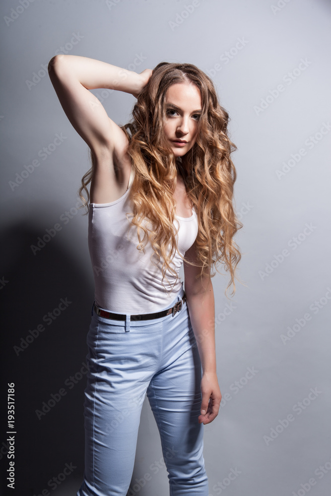 Portrait of a beautiful girl with long red hair on a gray background in the studio Portrait of a beautiful girl with long red hair on a gray background in the studio