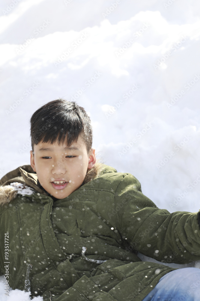 boy lay down on the snow and enjoy snow in the winter boy lay down on the snow and enjoy snow in the winter