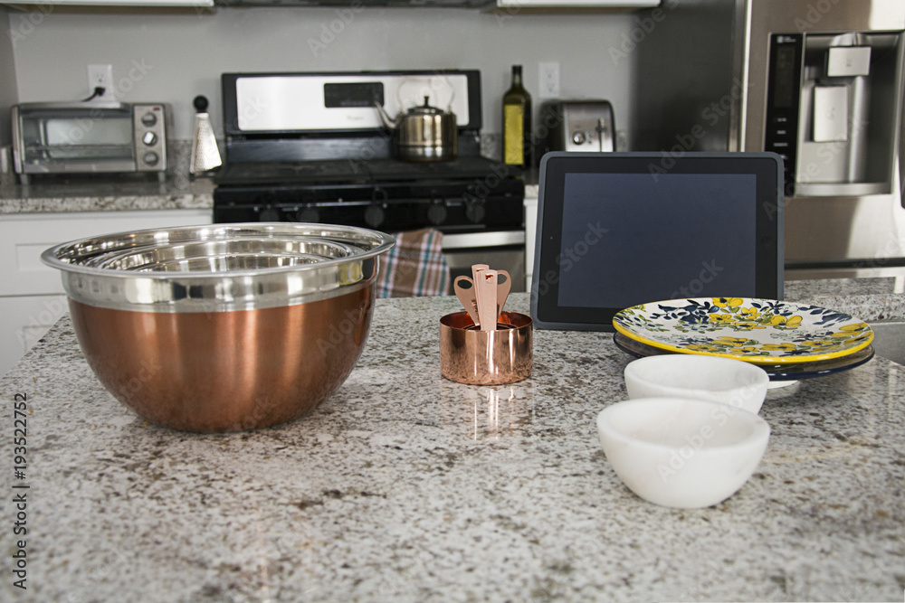 copper measuring cups and plates on granite counter with iPad copper measuring cups and plates on granite counter with iPad
