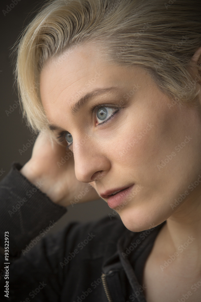 Fototapeta premium Head and shoulders portrait of young woman in windor light.