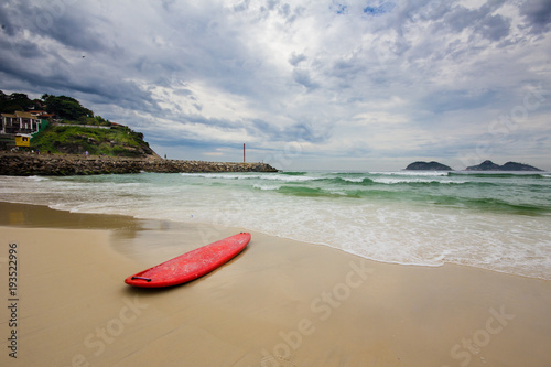 Fototapeta Naklejka Na Ścianę i Meble -  red surfboard laying on shorebreak