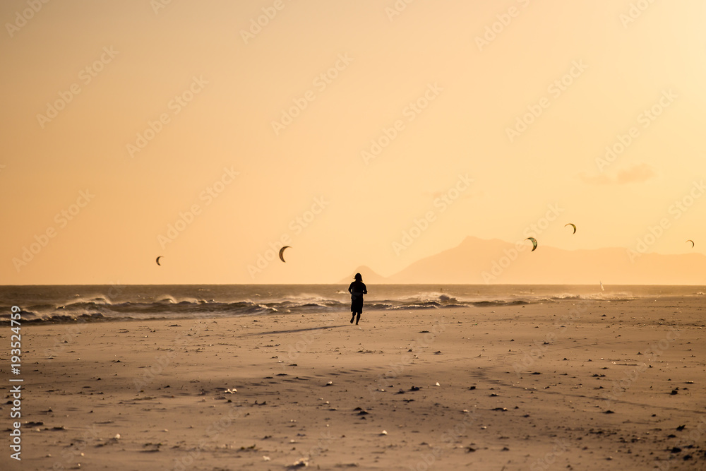 Silhouette of man running on the beach during sunset