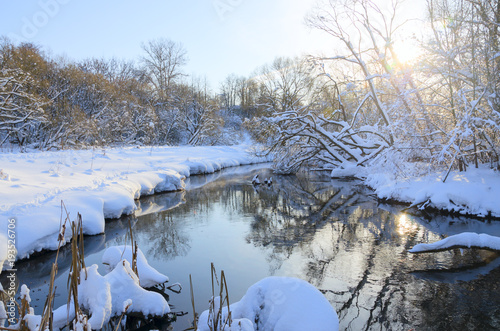 Frosty winter landscape with river.Snow covered trees on the riverbank.Cold sunny morning.River Konchura in Moscow region,Russia.  photo