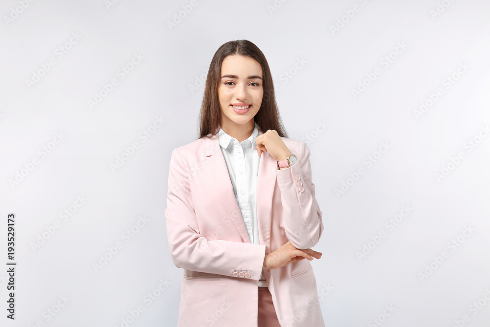 Beautiful young woman in elegant suit on light background Beautiful young woman in elegant suit on light background