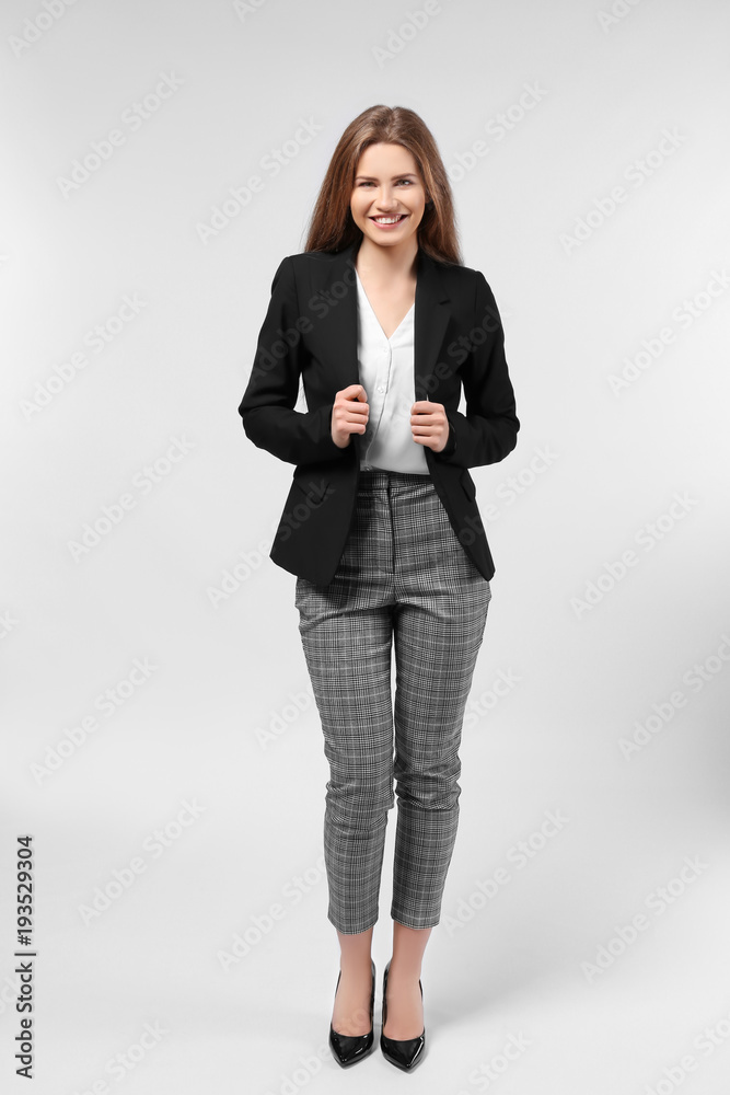 Beautiful young woman in elegant suit on light background Beautiful young woman in elegant suit on light background