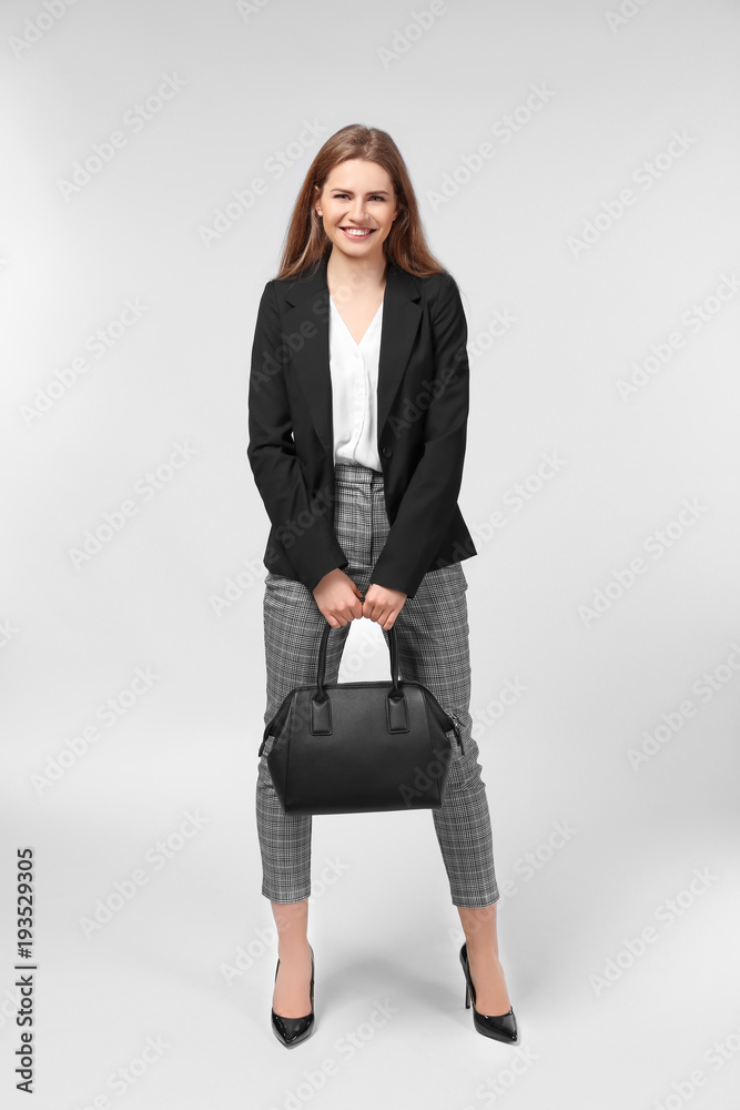 Beautiful young woman in elegant suit on light background Beautiful young woman in elegant suit on light background