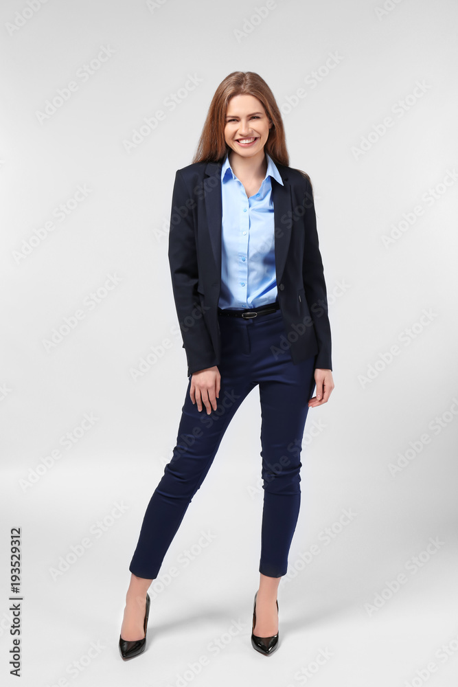 Beautiful young woman in elegant suit on light background Beautiful young woman in elegant suit on light background