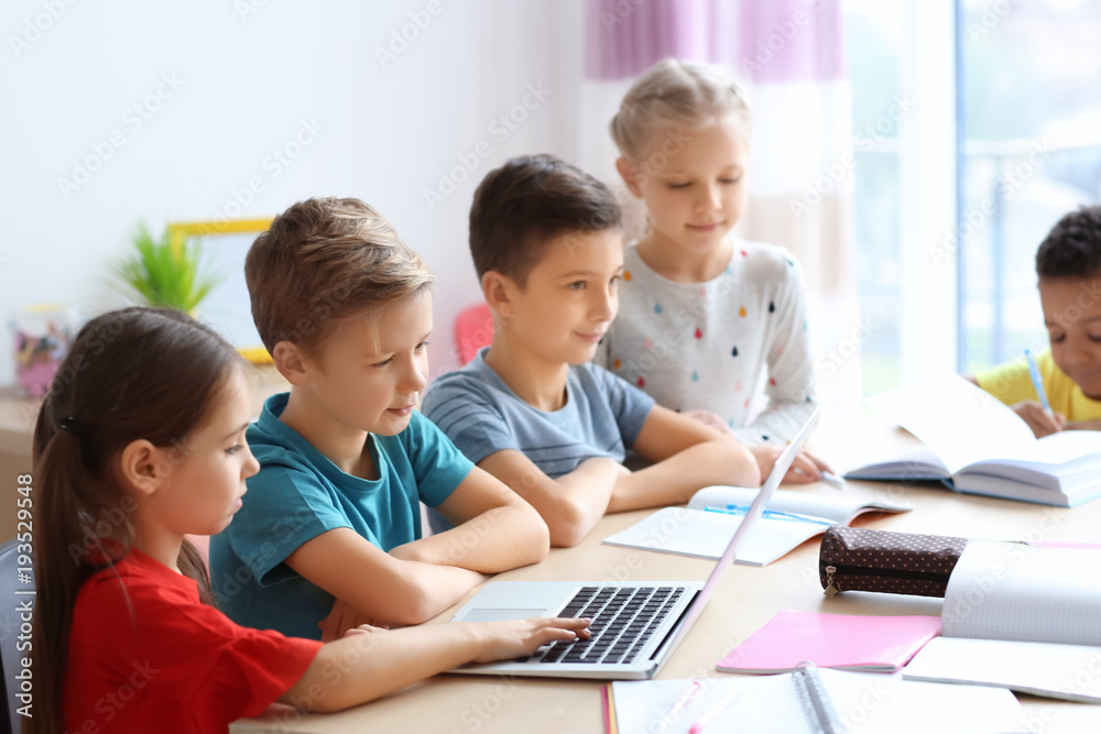 Cute children doing homework in classroom at school