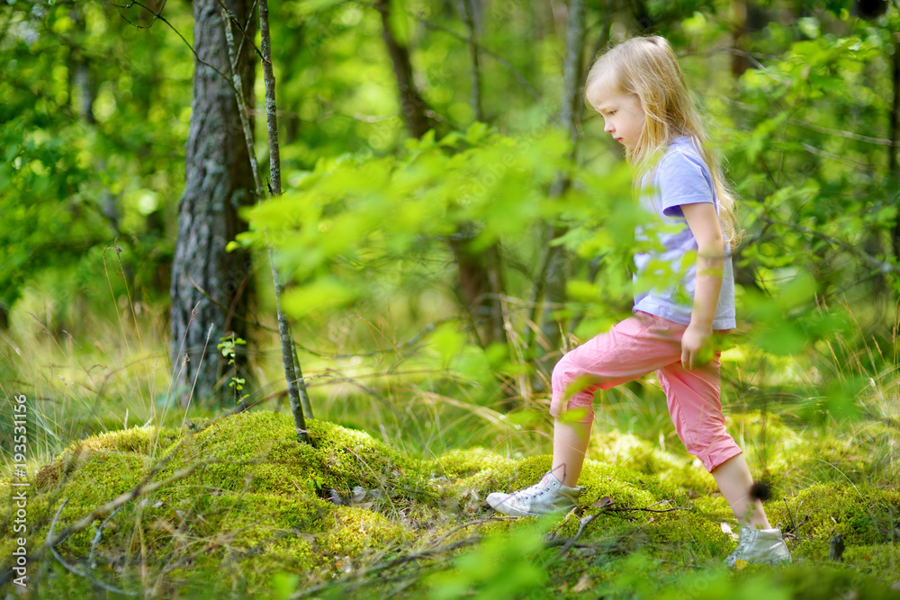 Cute little girl having fun during forest hike on beautiful summer day Cute little girl having fun during forest hike on beautiful summer day