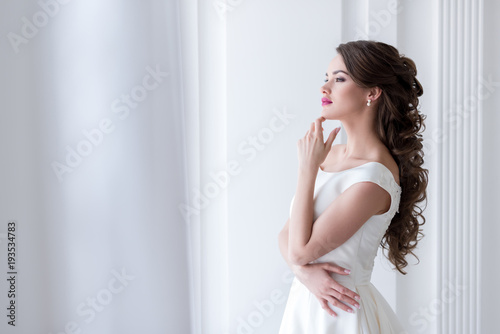 thoughtful young bride in wedding dress