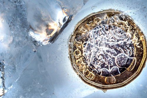 Frozen New British one pound sterling coin up close macro inside ice cubes photo