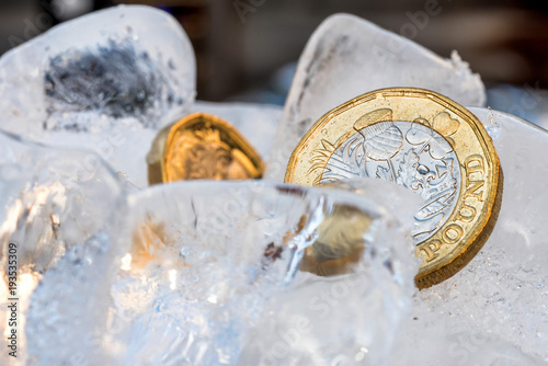 Frozen New British one pound sterling coin up close macro inside ice cubes photo