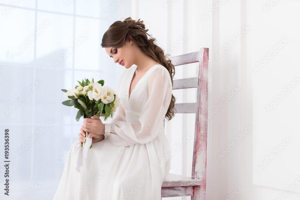 beautiful elegant bride sitting on big chair with wedding bouquet beautiful elegant bride sitting on big chair with wedding bouquet