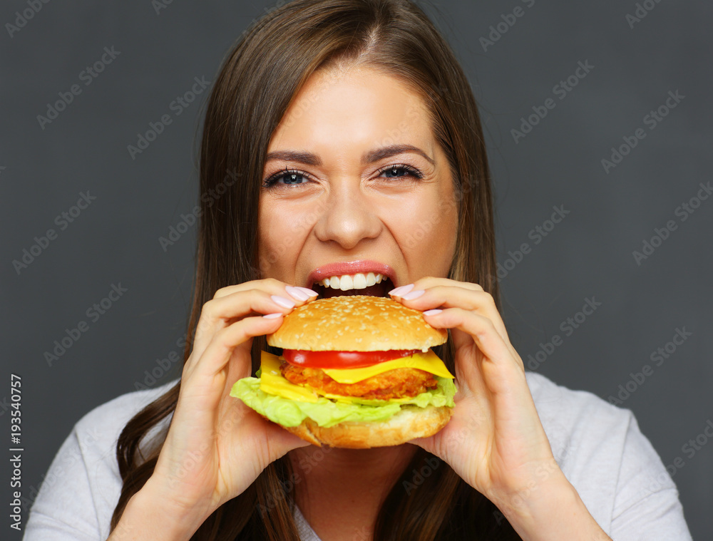 Young woman biting big burger isolated portrai