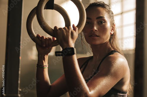 Determined woman exercising with gymnastic rings