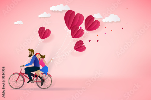 Happy couple is riding a bicycle together  and holding red balloons on pink  background.  Illustration of Love and Valentine Day. Paper cut style