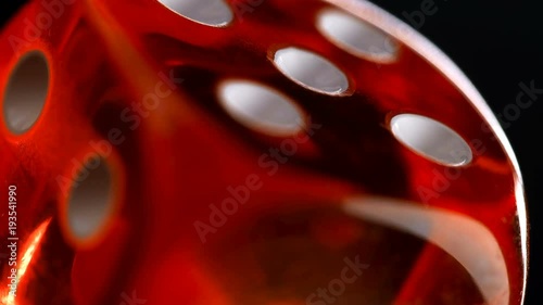 rotating red dice around its axis, on a black background