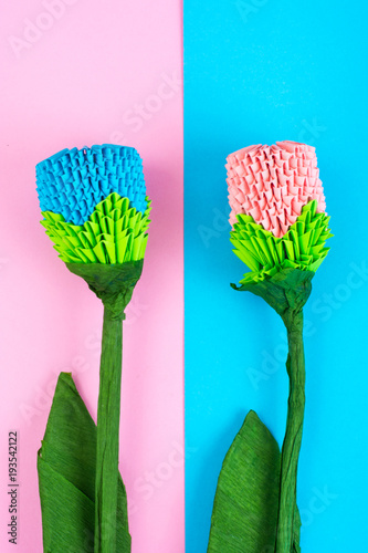 Multicolored paper origami flowers on pastel background