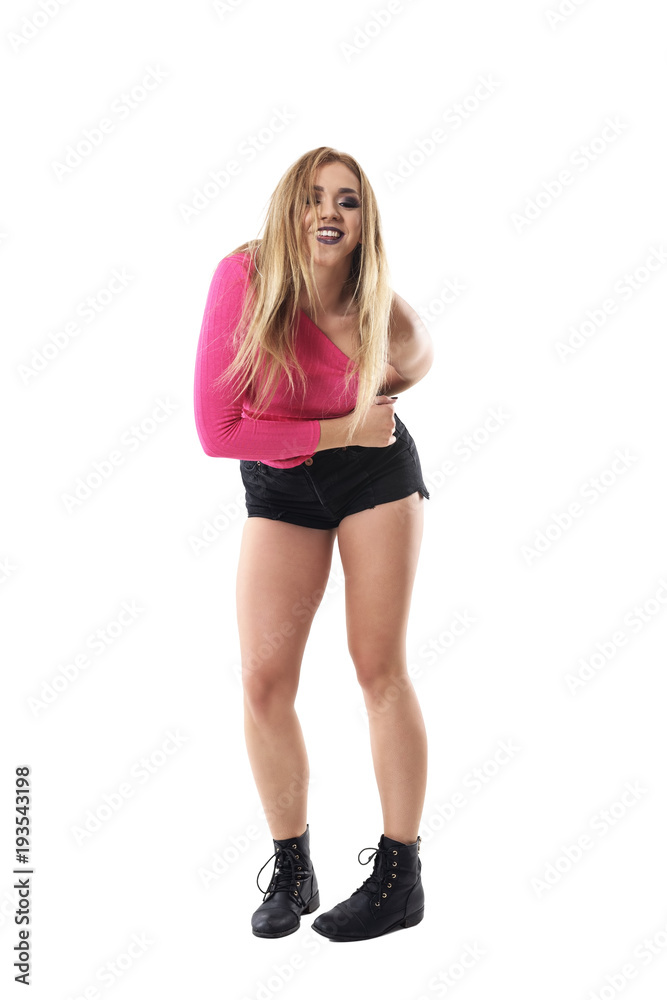 Bend dancing blonde woman with closed eyes wearing pink shirt. Full body length portrait isolated on white studio background. Bend dancing blonde woman with closed eyes wearing pink shirt. Full body length portrait isolated on white studio background.