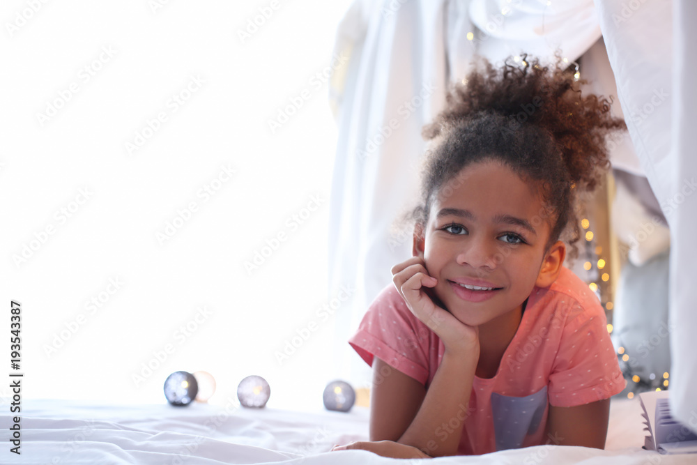 Cute African American girl lying on bed Stock Photo | Adobe Stock
