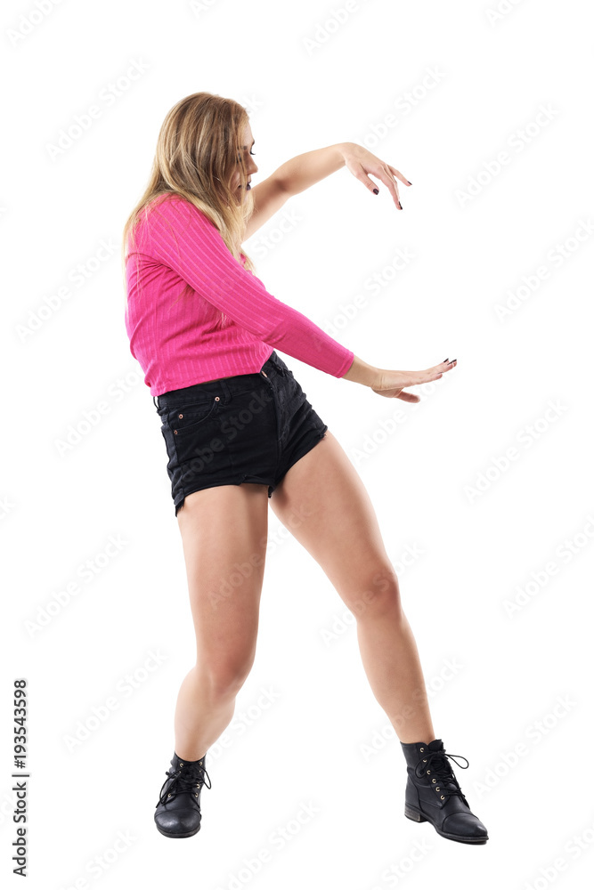 Graceful blonde woman in pink one sleeve top dancing. Side view. Full body length portrait isolated on white studio background. Graceful blonde woman in pink one sleeve top dancing. Side view. Full body length portrait isolated on white studio background.