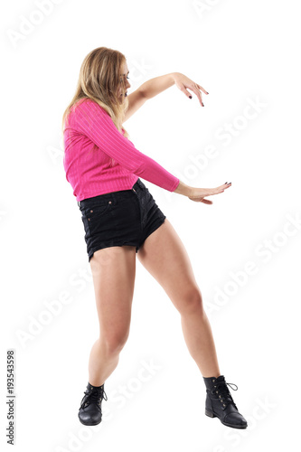 Graceful blonde woman in pink one sleeve top dancing. Side view. Full body length portrait isolated on white studio background.  © sharplaninac