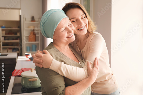 Young woman visiting her mother with cancer indoors photo