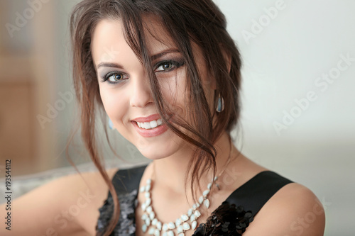Beautiful young woman with elegant jewelry indoors
